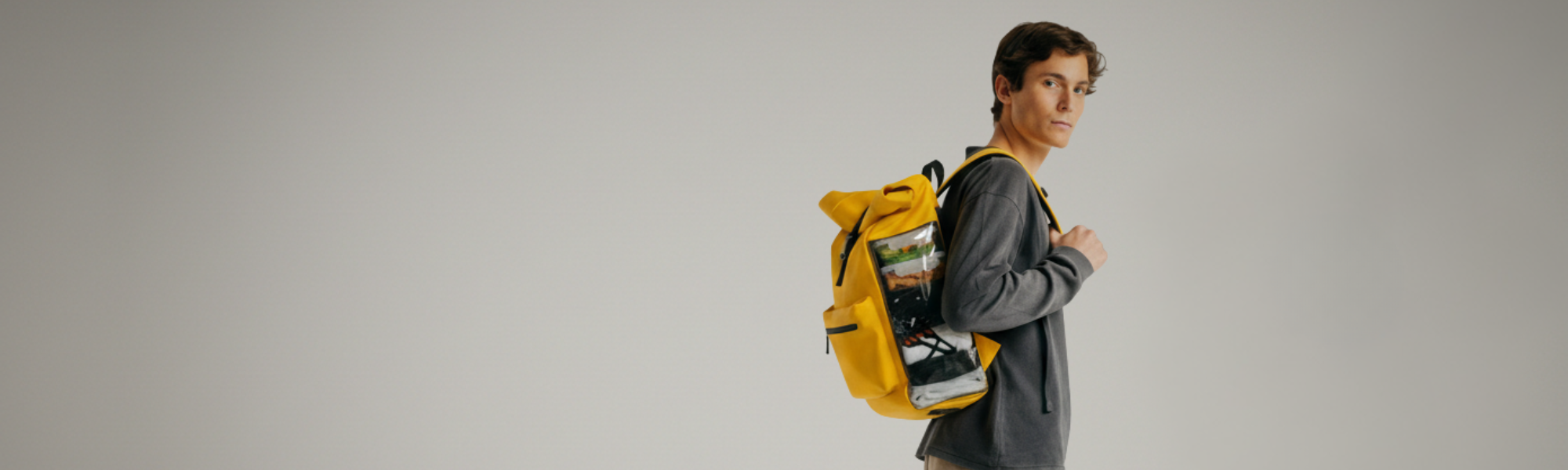 Chico con una mochila amarilla de pilatus donde se ven sus funcionalidades