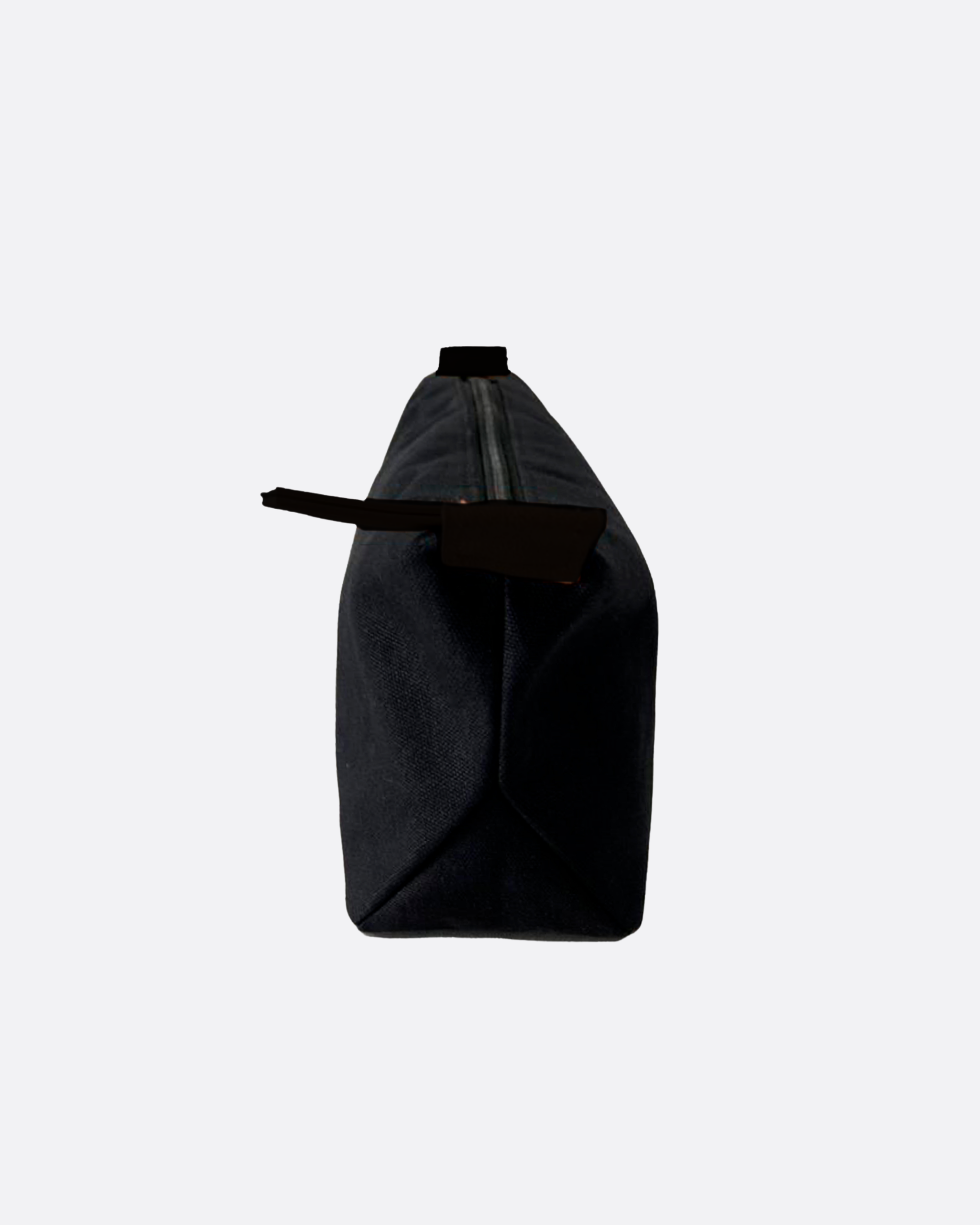Neceser rectangular negro con cremallera superior y tira de agarre, mostrado de lado sobre fondo blanco minimalista
