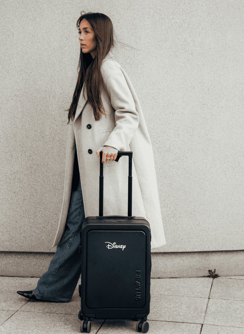 Chica con abrigo largo con maleta de cabina personalizada para Disney