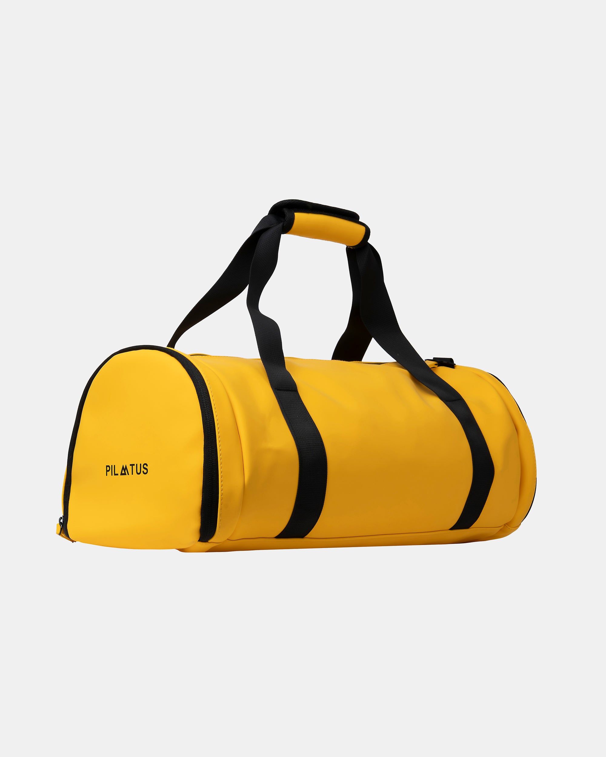 Bolsa de deporte amarilla con asas y correa negras, asa superior acolchada; fondo blanco neutro. Texto: PILATUS