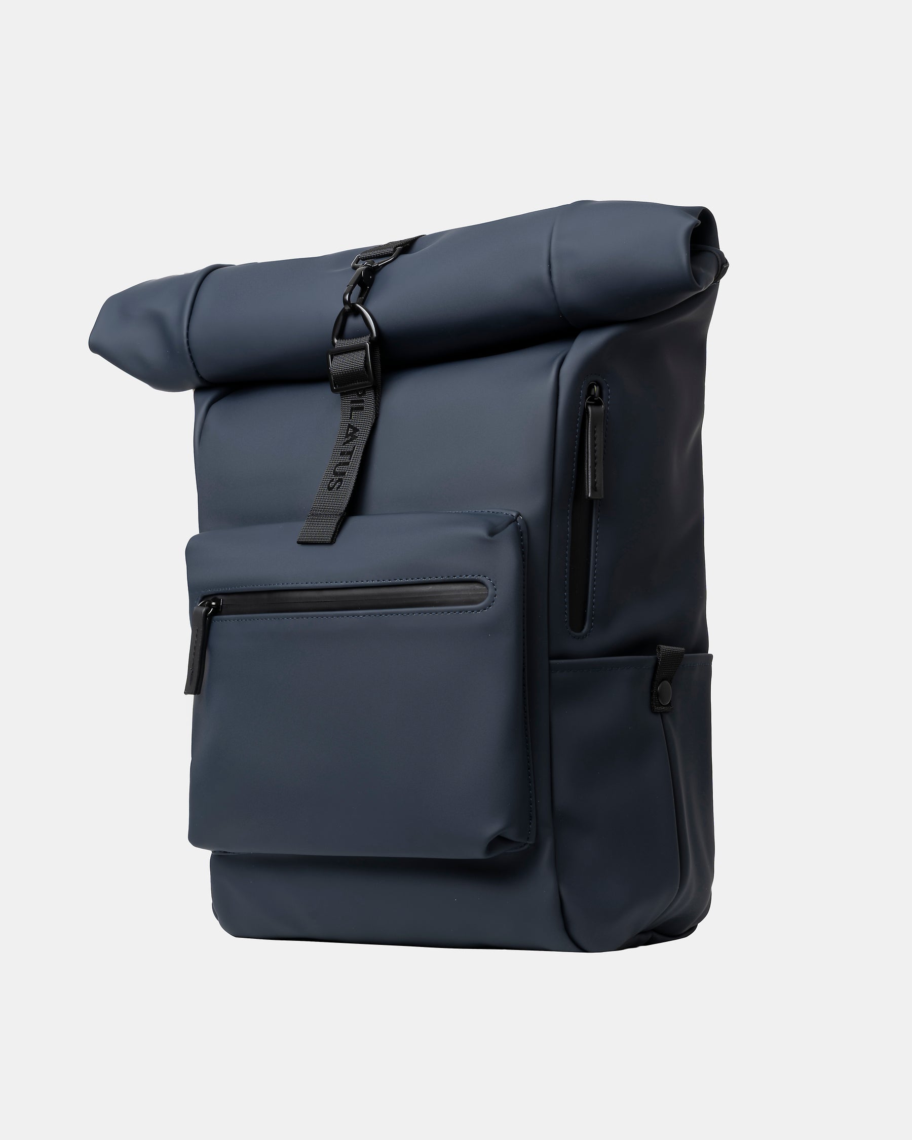 Mochila roll-top azul marino sobre fondo neutro; cierre con cinta y hebilla, bolsillo frontal con cremallera. Texto: PILATUS