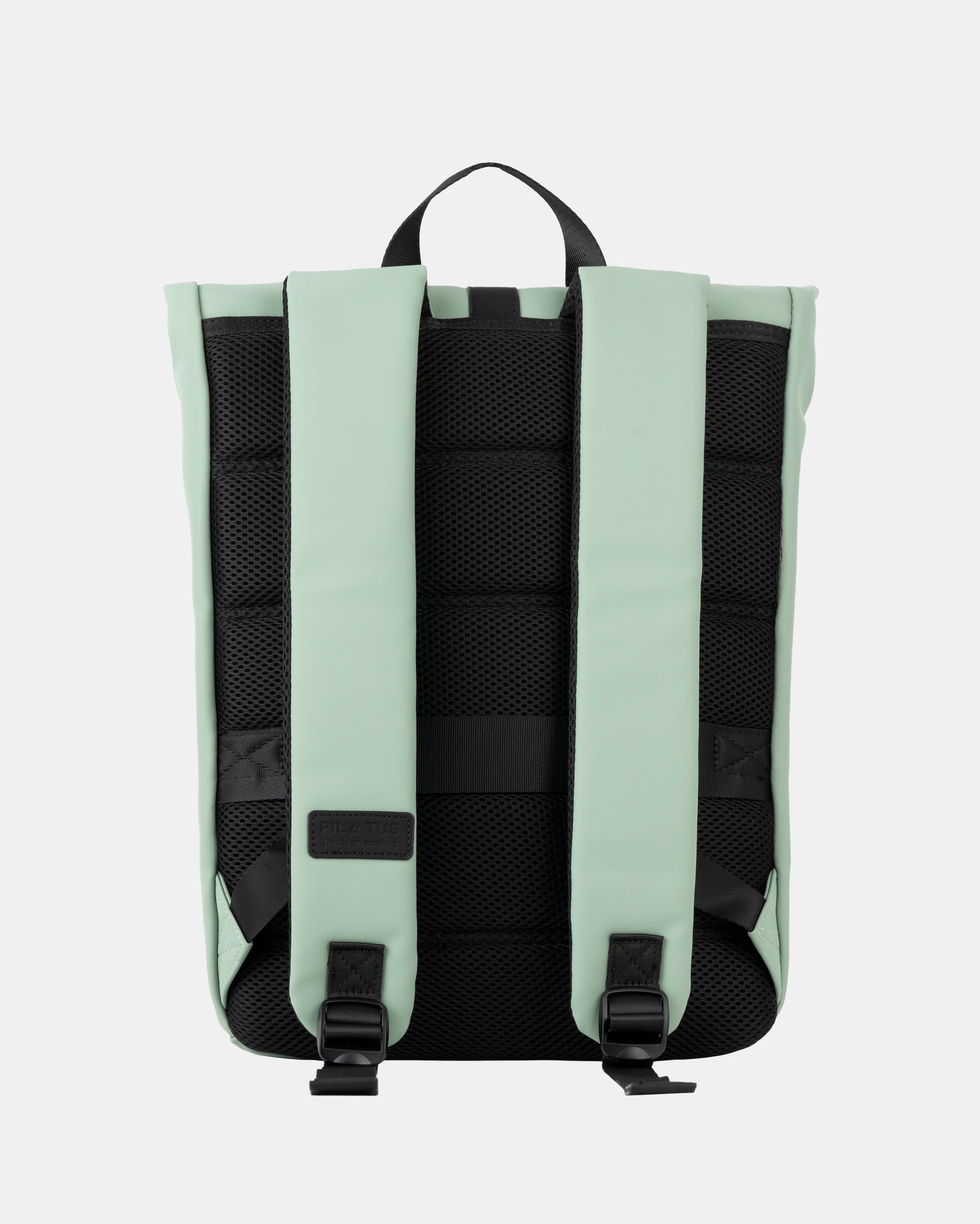 Mochila: respaldo de malla negra y tirantes acolchados color menta; asa superior negra y hebillas inferiores. Texto: PILATUS