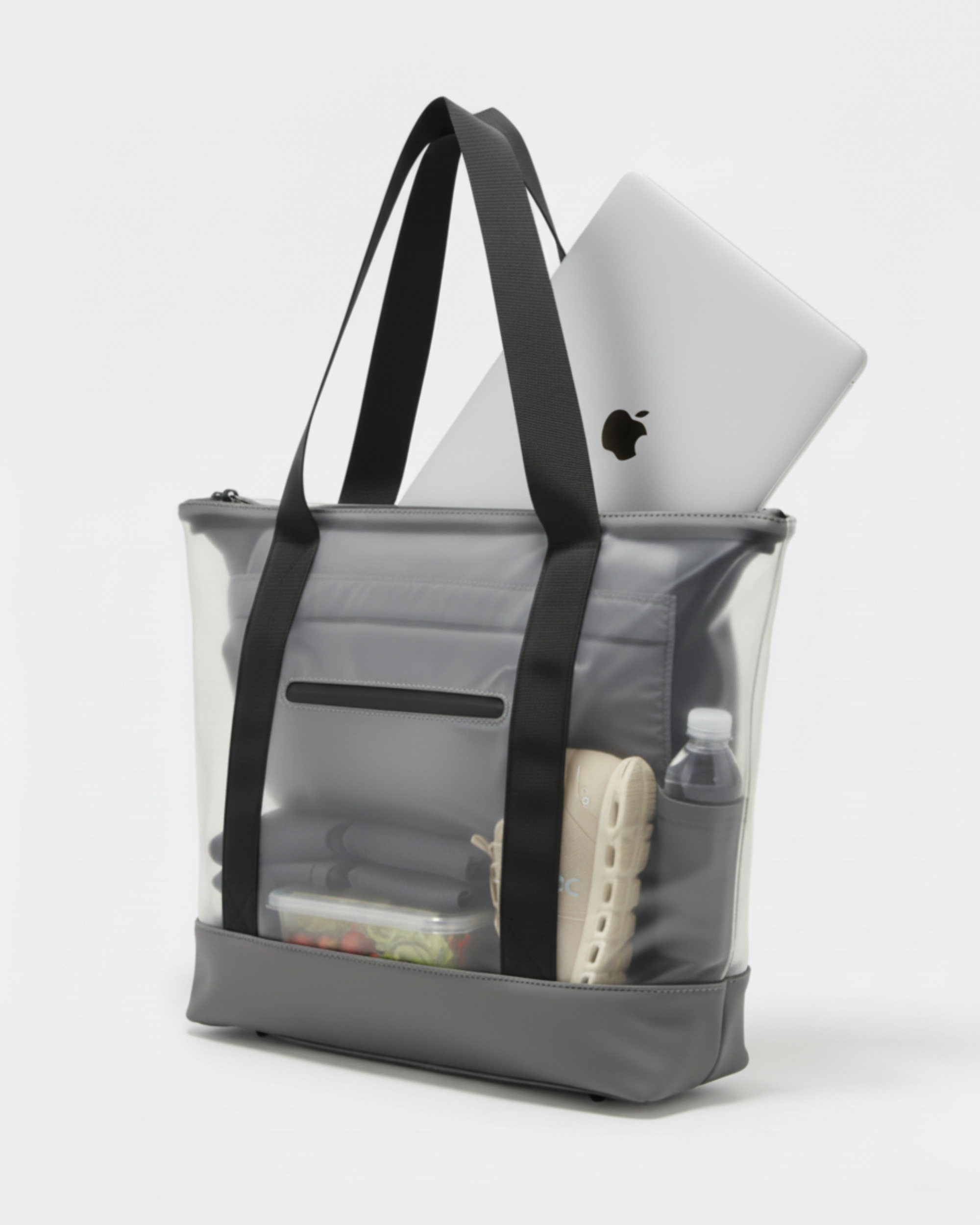 Tote bag transparente con ordenador, zapatillas de deporte, botella, un tupper y ropa de gimansio.