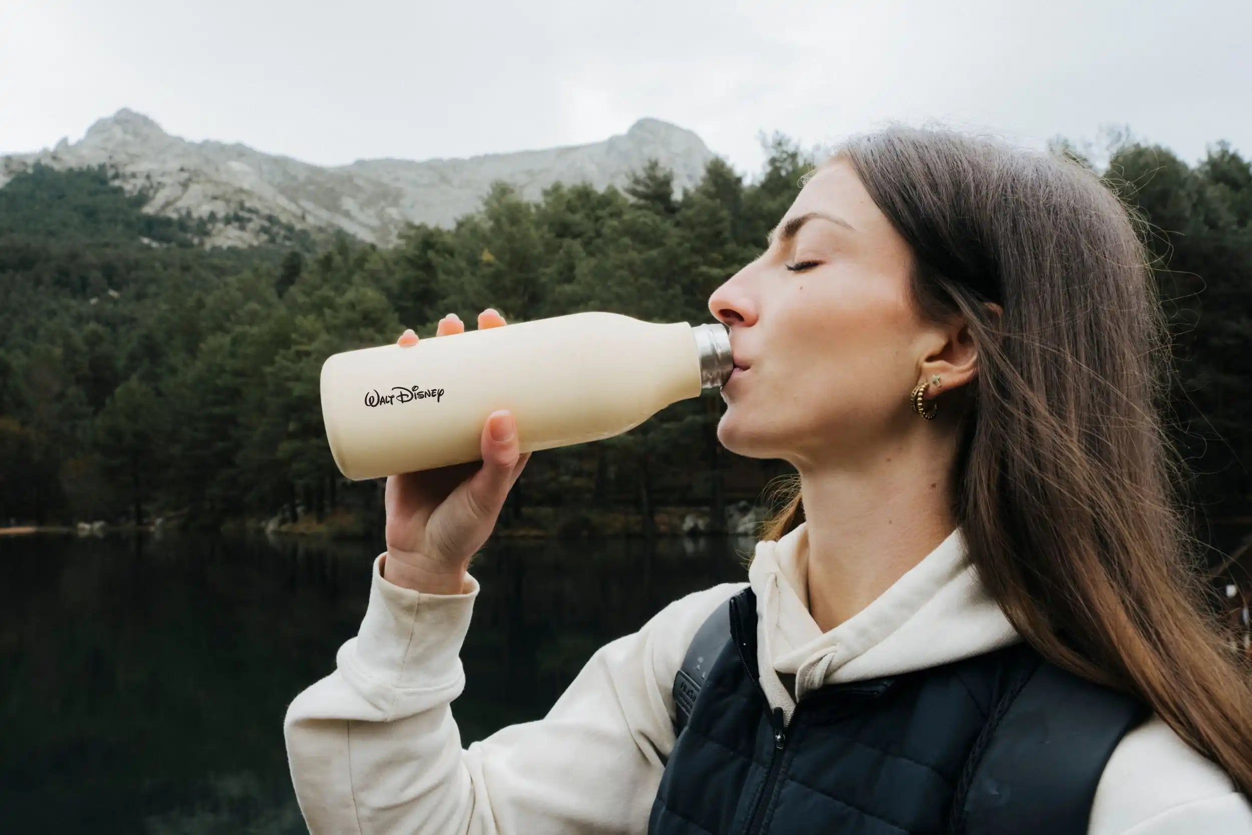 Mujer bebiendo de botella urban light yellow de Pilatus brand con logotipo personalizado de la empresa Walt Disney