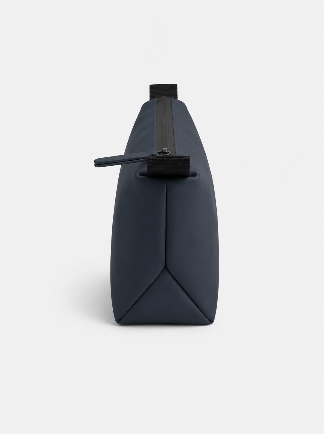 Neceser azul marino rectangular con cierre superior impermeable y tirador de goma; base triangular plegada