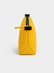 Neceser amarillo con cremallera vertical negra y tirador amarillo; asa lateral negra, base con costuras triangulares