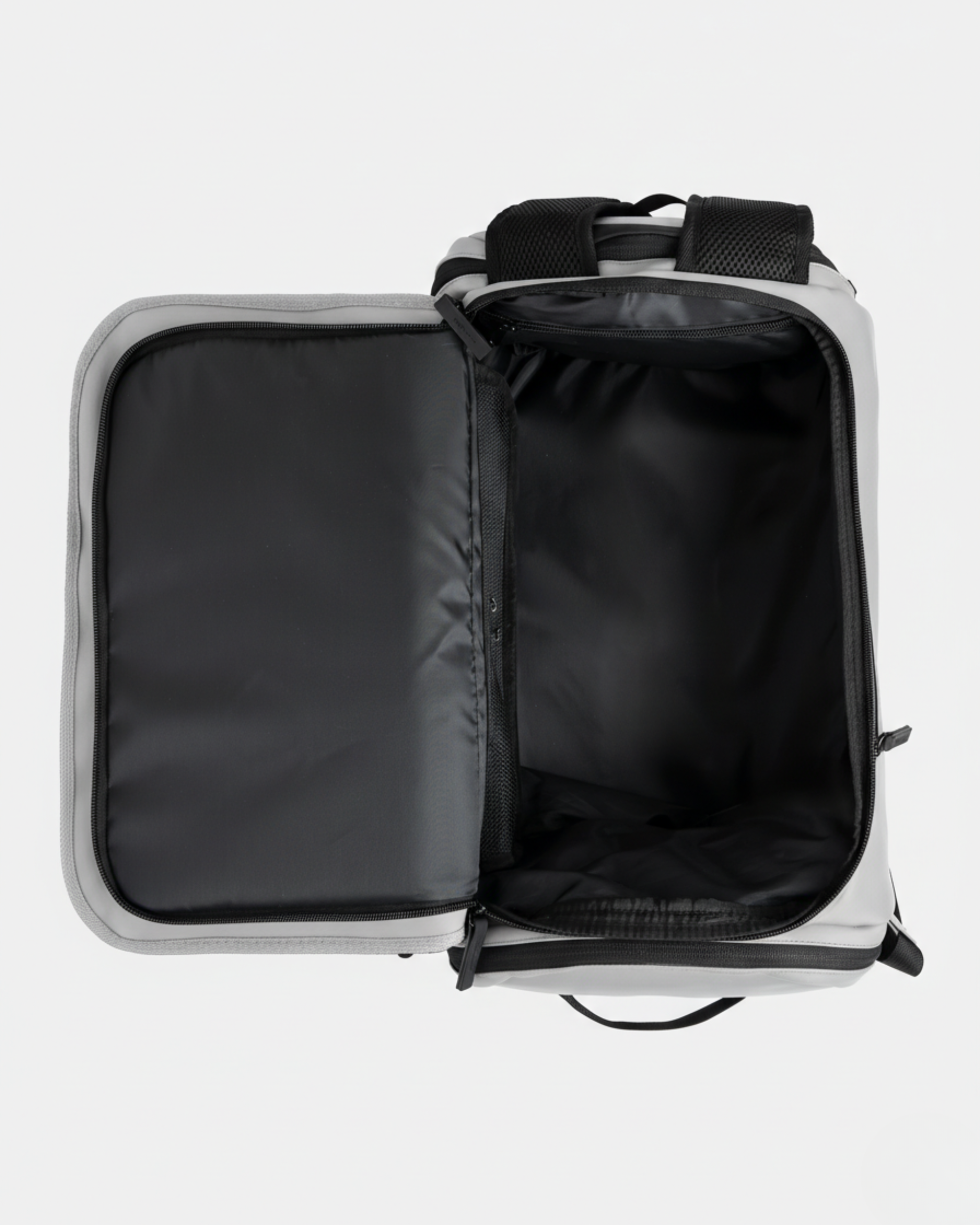 Mochila gris abierta con interior negro; compartimentos acolchados y cierre de cremallera
