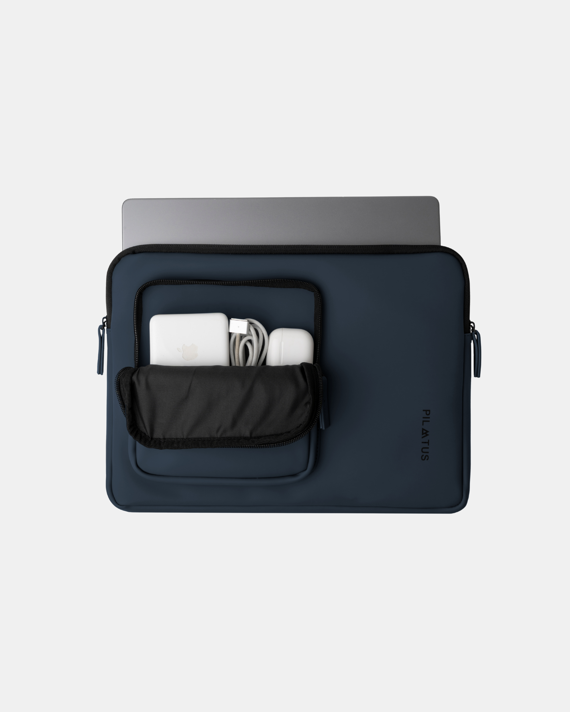 Funda para portátil azul marino con bolsillo frontal abierto que contiene cargador. Texto: PILATUS