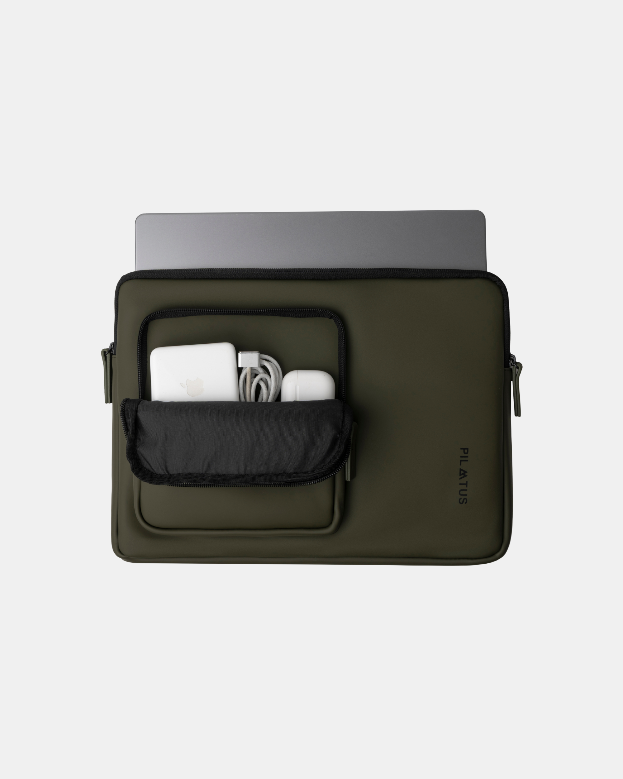 Mochila verde oliva para portátil con bolsillo frontal abierto que contiene cargador blanco. Texto: PILATUS
