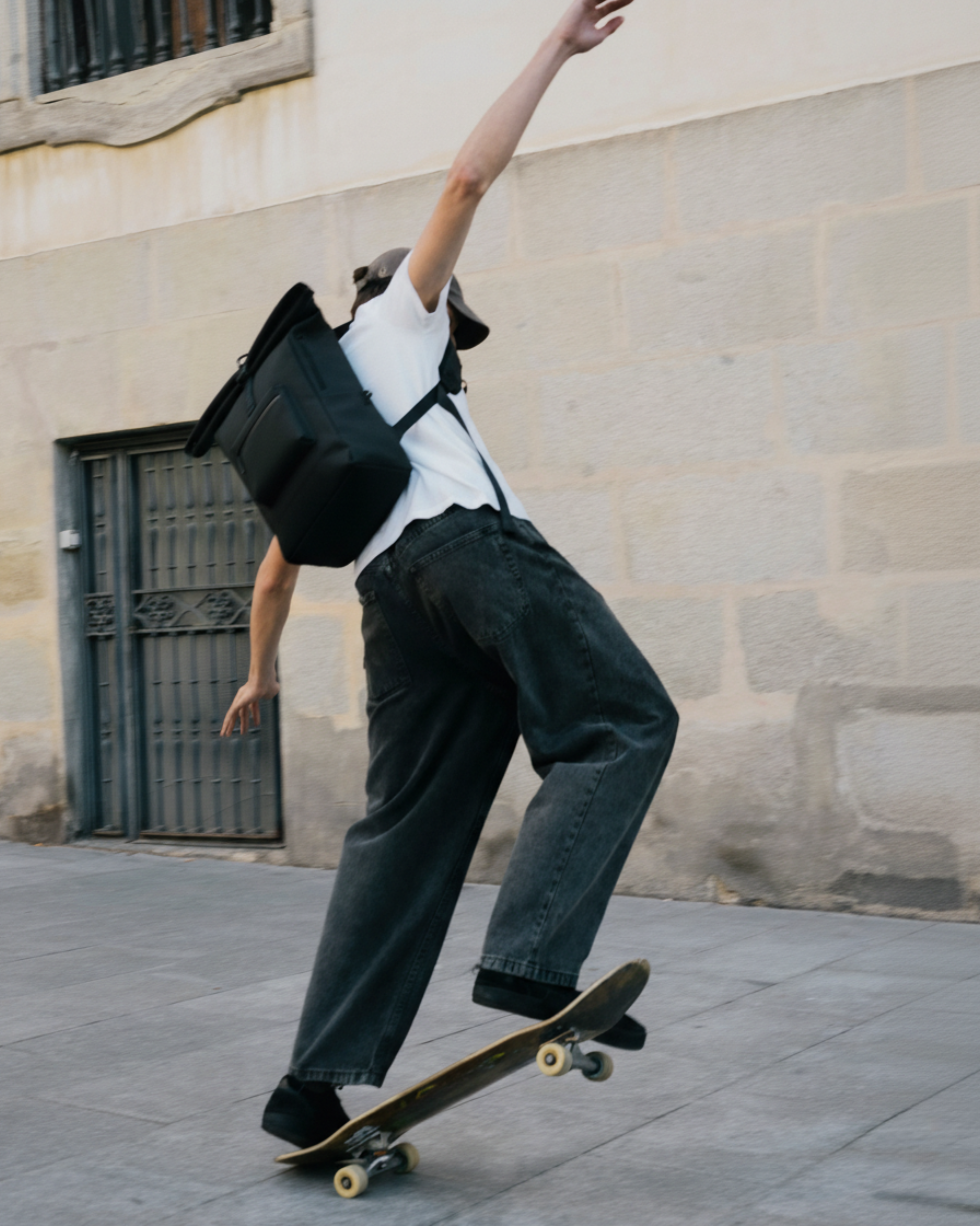 Chico montado en un skate con la mochila mini urban.