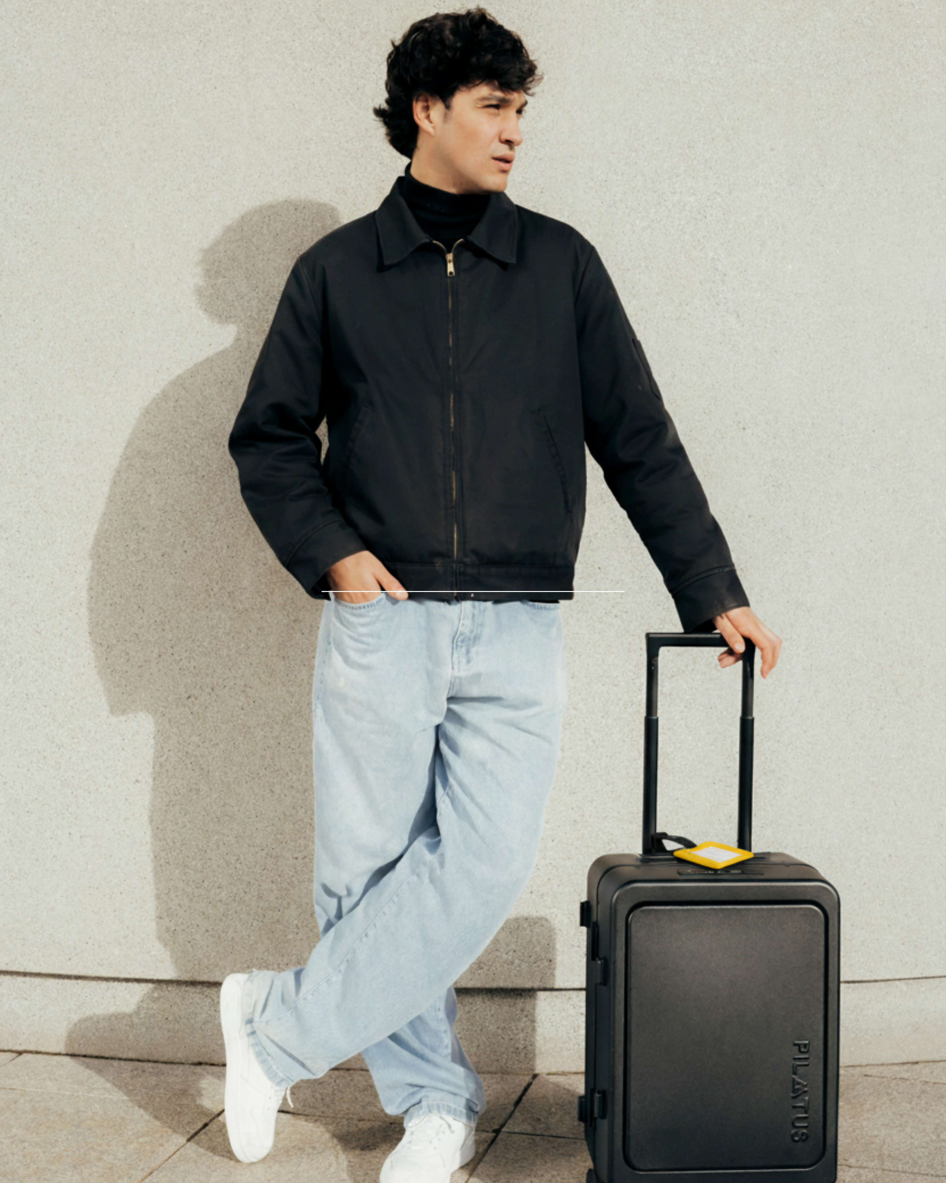 Chico con maleta y con el travel tag amarillo.